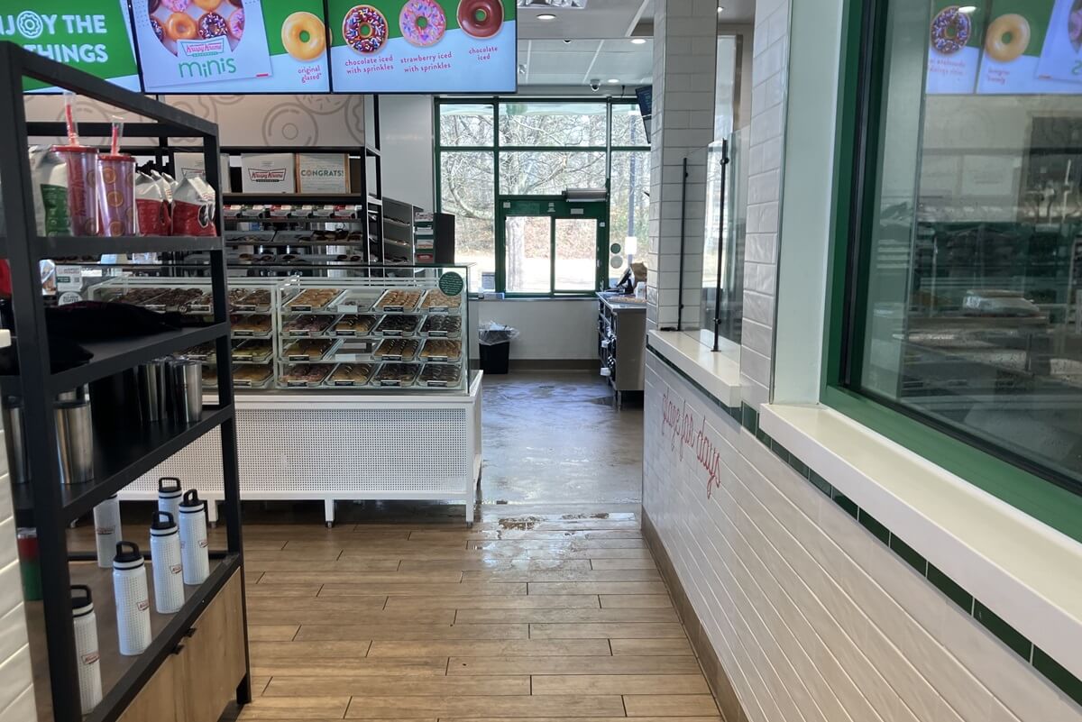 Tile line area with merchandise shelf and donuts case inside Krispy Kreme located in Atlanta, Georgia. Installation work done by Nationwide Fixture Installations.