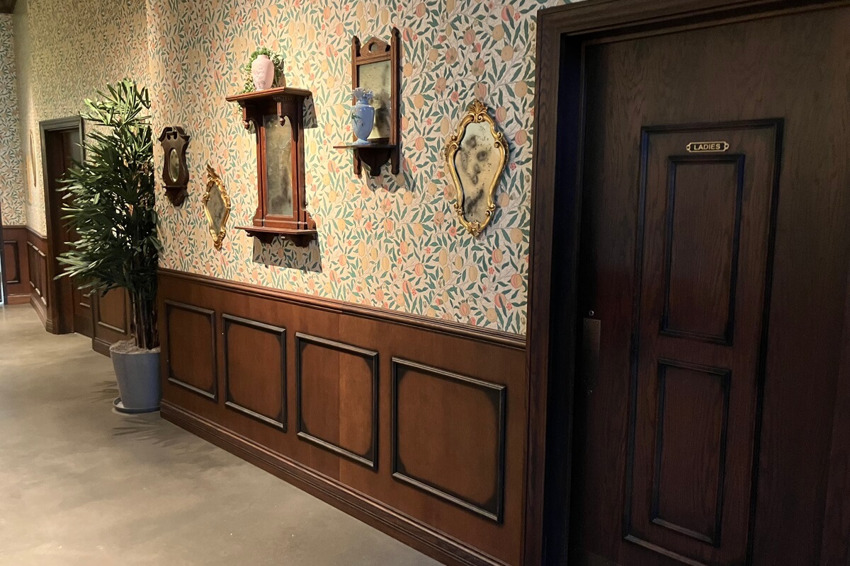 Hallway with restrooms located in Flight Club in Atlanta, Georgia. Showcase wood paneling and doors installed by Nationwide Fixture Installations.