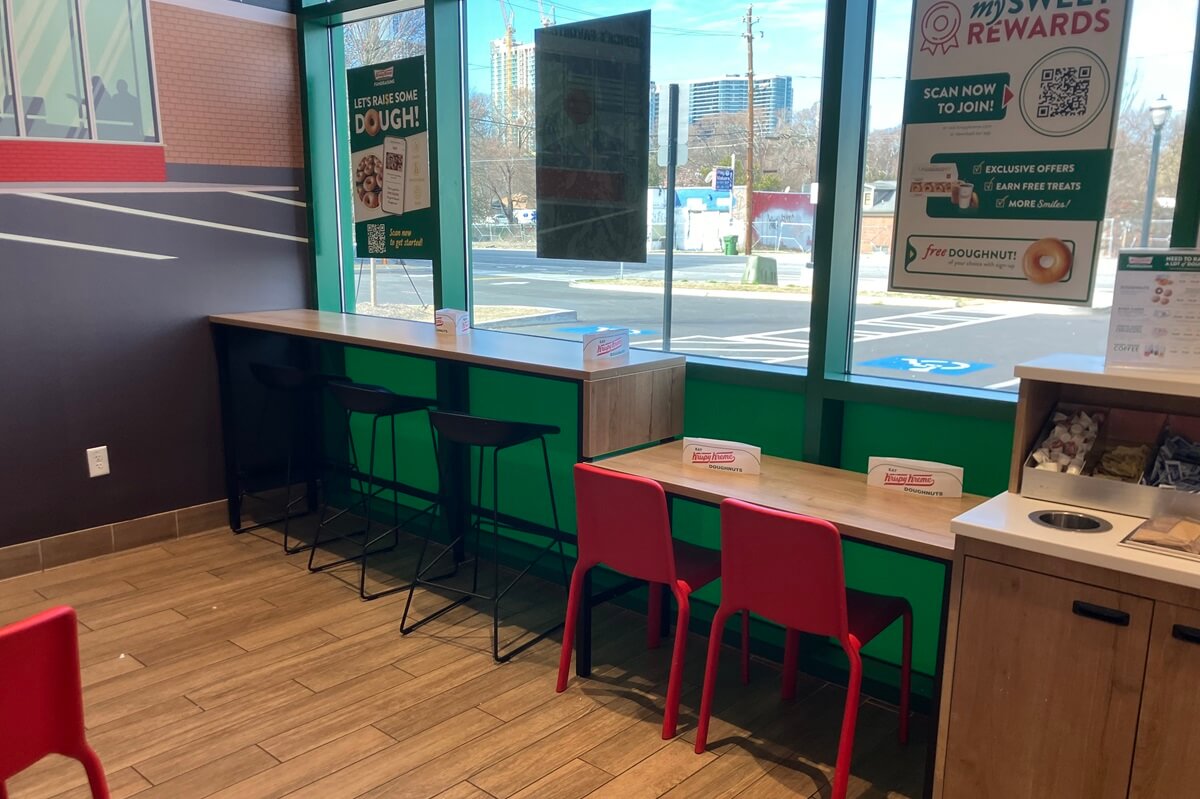 Small sitting area and tables inside Krispy Kreme located in Atlanta, Georgia. Installation work done by Nationwide Fixture Installations.