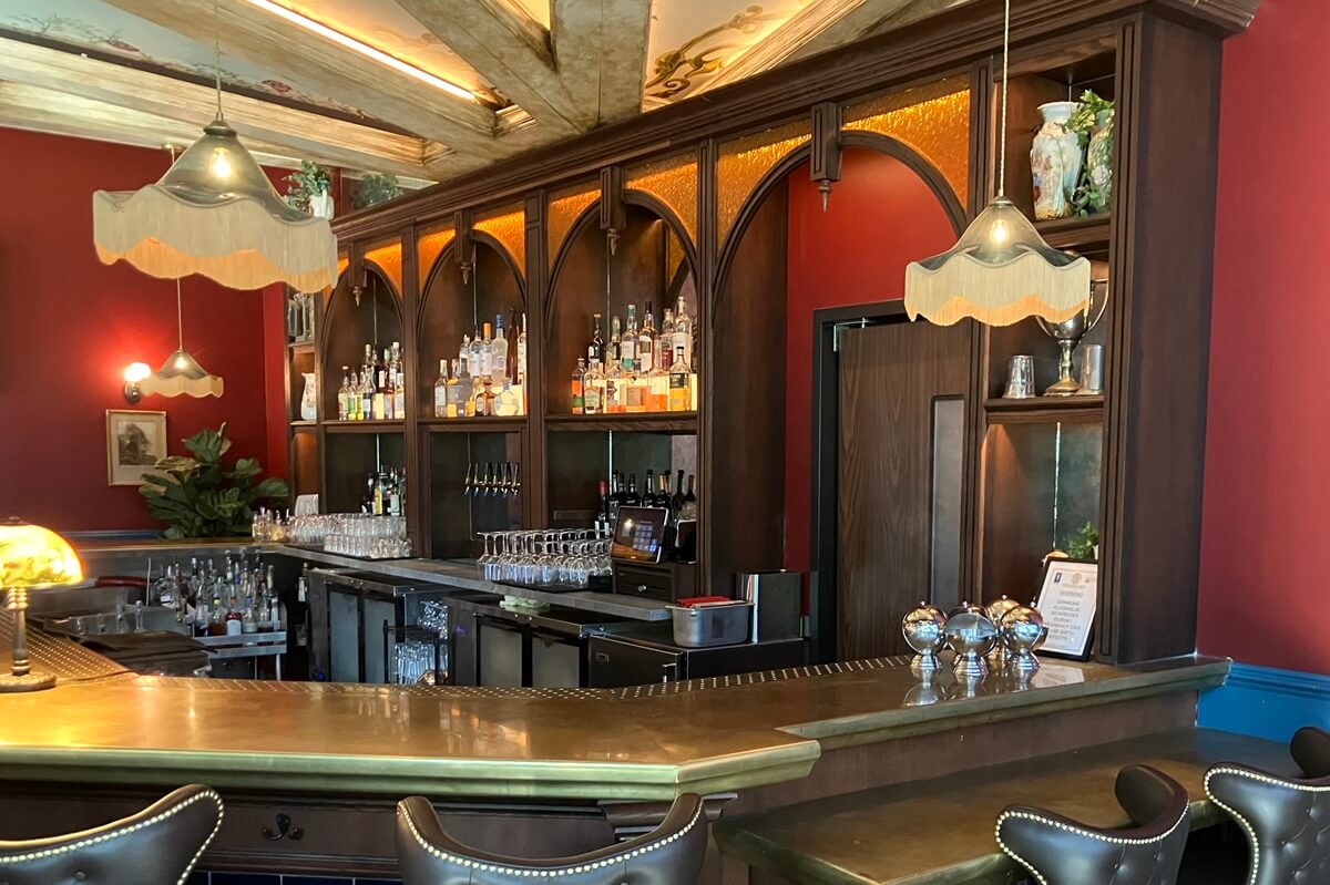 Bar area with wood beams on ceiling located in Flight Club in Atlanta, Georgia. Installation of millwork done by Nationwide Fixture Installations.